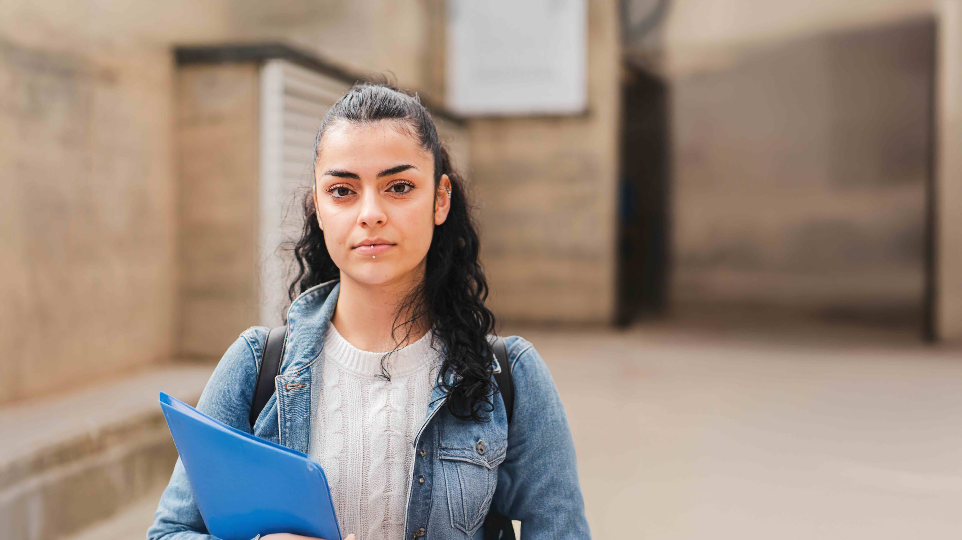 Portrait of woman in denim jacket holding a file